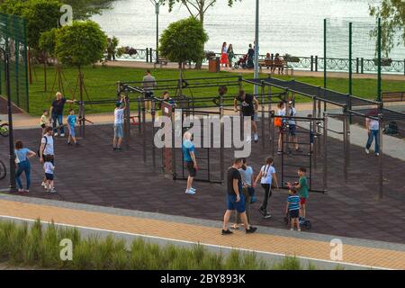 Kiev, Ucraina - 7 giugno 2020: Parco Natalka su Obolon a Kiev. In una calda serata estiva, la gente cammina e gioca sport nella piazza dello sport. Foto Stock