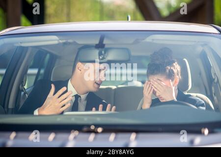 Donna che ricopre il viso con le mani e un uomo serio Foto Stock