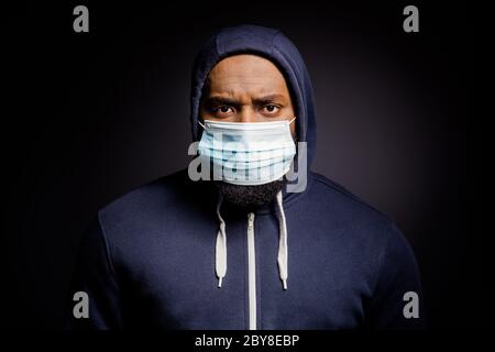 Ritratto di insoddisfatto afro americano guy tassa sconvolto gente africana discriminazione saccheggio indossare moda maglione maschera medica isolato su nero Foto Stock