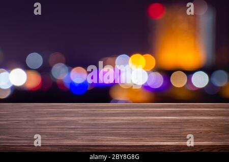 Notte crepuscolo luce offuscata bokeh nel centro di bangkok vuoto di legno scuro tavolo sfondo astratto per montaggio prodotto esposizione o design. Foto Stock