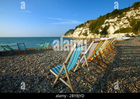 Sedie a sdraio sulla spiaggia di mattina presto, birra, Devon, Inghilterra, Regno Unito Foto Stock