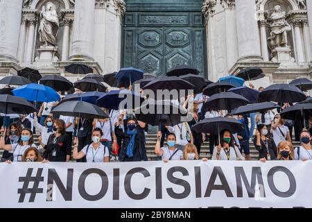 VENEZIA, ITALIA - 09 GIUGNO: Guide turistiche (vestite di bianco) e tour leader (vestite di nero) protestano per riportare il loro lavoro nella chiesa della Salute Foto Stock