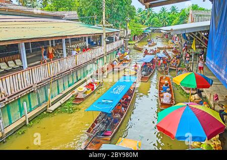 DAMNOEN SADUAK, THAILANDIA - 13 MAGGIO 2019: Canale occupato (klong) al mercato galleggiante di Ton Khem con una vista dall'alto sul traffico turistico pesante delle barche, numerosi cibi a. Foto Stock