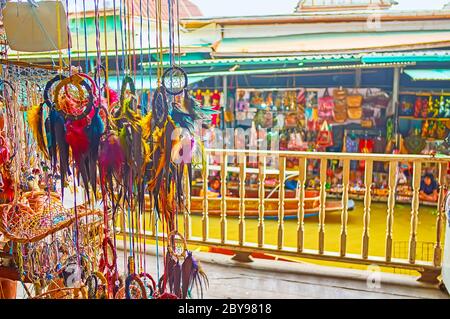 La vista su bancarelle, canale e barche sampang attraverso i sognatori sospesi nel padiglione del mercato galleggiante Damnoen Saduak, Thailandia Foto Stock