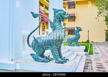 La coppia di leoni di bronzo singha protegge l'ingresso al padiglione Phra Vihara Somdej del tempio di marmo di Wat Benchamabophit Dusitvanaram, Bangkok, Tha Foto Stock