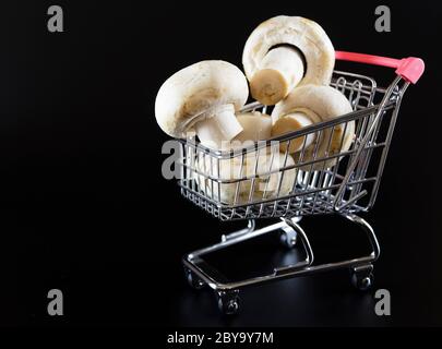 funghi champignon in un carrello su sfondo nero 3 Foto Stock