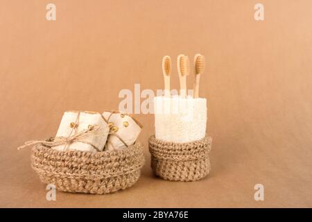 Set di strumenti per bagno naturale e per la spa, concetto di stile di vita e di zero sprechi sostenibili. Spazzolini da denti in legno e sapone naturale, su carta kraft Foto Stock
