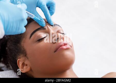 Giovane donna nera che riceve iniezione di botox al salone di bellezza Foto Stock