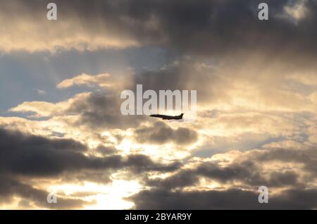 VOLO 419: Gli aerei commerciali decolorano da un vicino aeroporto internazionale Newark nel New Jersey nel tramonto del paesaggio nuvoloso in una giornata di primavera. Foto Stock