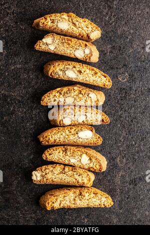 Biscotti dolci alla cantuccina. Biscotti di mandorle su tavola nera. Vista dall'alto. Foto Stock