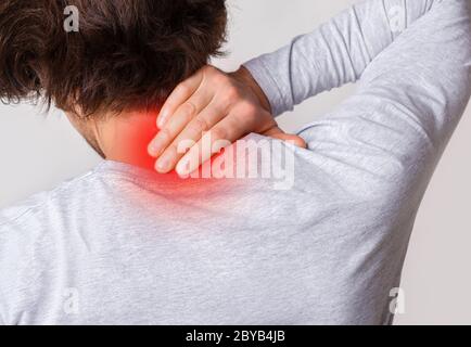 Infiammazione muscolare del collo. L'uomo tiene per irritare il punto evidenziato in rosso Foto Stock