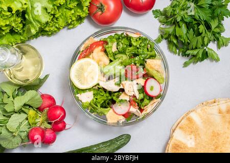 Insalata di pita mediterranea che comprende lattuga, pomodori, cetrioli, ravanelli e pita Foto Stock