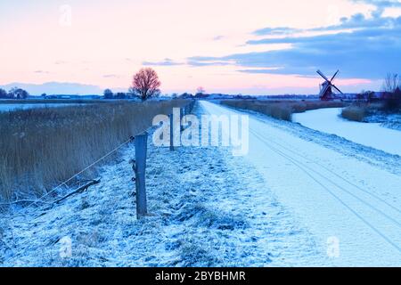 mulino a vento e percorso per biciclette in inverno Olanda Foto Stock