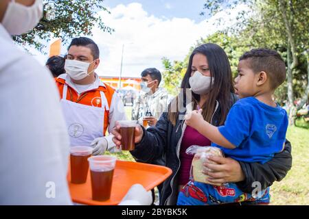 Bogotà, Colombia. 9 Giugno 2020. Una madre con i suoi figli riceve donazioni. Circa 500 migranti venezuelani hanno vissuto alcune settimane fa in Calle 195 con Autopista Norte nella città di Bogotà a causa della pandemia. Credit: Daniel Garzon Herazo/ZUMA Wire/Alamy Live News Foto Stock