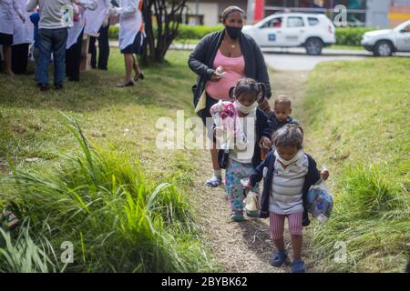 Bogotà, Colombia. 9 Giugno 2020. I bambini ricevono donazioni e cibo. Circa 500 migranti venezuelani hanno vissuto alcune settimane fa in Calle 195 con Autopista Norte nella città di Bogotà a causa della pandemia. Credit: Daniel Garzon Herazo/ZUMA Wire/Alamy Live News Foto Stock