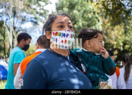 Bogotà, Colombia. 9 Giugno 2020. I bambini ricevono donazioni e cibo. Circa 500 migranti venezuelani hanno vissuto alcune settimane fa in Calle 195 con Autopista Norte nella città di Bogotà a causa della pandemia. Credit: Daniel Garzon Herazo/ZUMA Wire/Alamy Live News Foto Stock