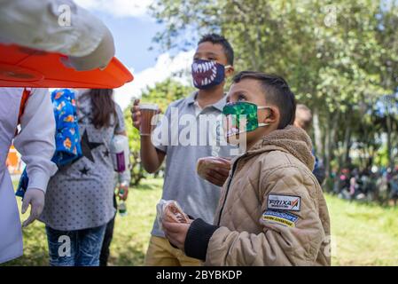 Bogotà, Colombia. 9 Giugno 2020. I bambini ricevono donazioni e cibo. Circa 500 migranti venezuelani hanno vissuto alcune settimane fa in Calle 195 con Autopista Norte nella città di Bogotà a causa della pandemia. Credit: Daniel Garzon Herazo/ZUMA Wire/Alamy Live News Foto Stock