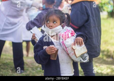 Bogotà, Colombia. 9 Giugno 2020. I bambini ricevono donazioni e cibo. Circa 500 migranti venezuelani hanno vissuto alcune settimane fa in Calle 195 con Autopista Norte nella città di Bogotà a causa della pandemia. Credit: Daniel Garzon Herazo/ZUMA Wire/Alamy Live News Foto Stock