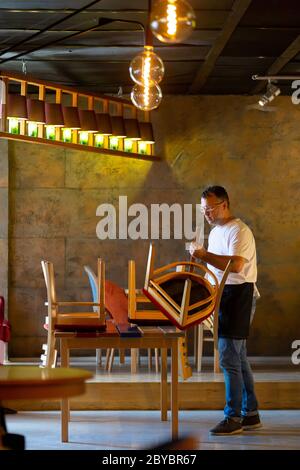 Il cameriere prepara il Ristorante per la riapertura dopo la quarantena Foto Stock