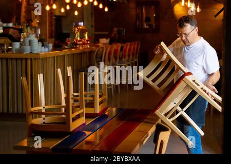 Il cameriere prepara il Ristorante per la riapertura dopo la quarantena Foto Stock