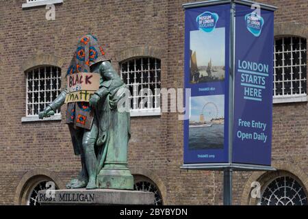 Ore prima che fosse rimossa dalla fondazione Canal and River Trust, la statua del mercante di schiavi, Robert Milligan si trova coperto da attivisti della materia Black Lives fuori dal Museo dei Docklands di Londra sul West India Quay, un tempo il magazzino più lungo del mondo pagato dai profitti della schiavitù, il 9 giugno 2020, A Londra, Inghilterra. Dopo le proteste di George Floyd negli Stati Uniti e nel Regno Unito Black Lives, i gruppi che chiedono la rimozione di statue e nomi di strada con collegamenti al commercio degli schiavi, Milligan e altre statue di profitatori della schiavitù britannica, sono diventati un punto di protesta. Foto Stock