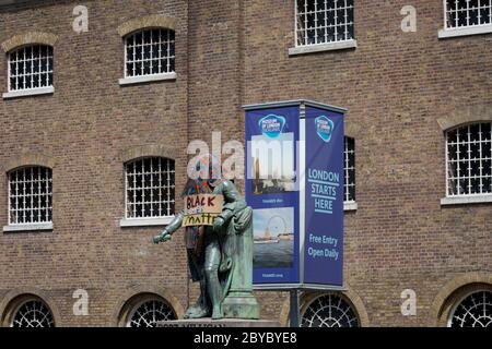 Ore prima che fosse rimossa dalla fondazione Canal and River Trust, la statua del mercante di schiavi, Robert Milligan si trova coperto da attivisti della materia Black Lives fuori dal Museo dei Docklands di Londra sul West India Quay, un tempo il magazzino più lungo del mondo pagato dai profitti della schiavitù, il 9 giugno 2020, A Londra, Inghilterra. Dopo le proteste di George Floyd negli Stati Uniti e nel Regno Unito Black Lives, i gruppi che chiedono la rimozione di statue e nomi di strada con collegamenti al commercio degli schiavi, Milligan e altre statue di profitatori della schiavitù britannica, sono diventati un punto di protesta. Foto Stock