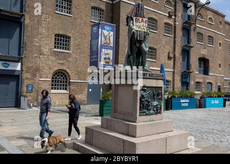 Ore prima che fosse rimossa dalla fondazione Canal and River Trust, la statua del mercante di schiavi, Robert Milligan si trova coperto da attivisti della materia Black Lives fuori dal Museo dei Docklands di Londra sul West India Quay, un tempo il magazzino più lungo del mondo pagato dai profitti della schiavitù, il 9 giugno 2020, A Londra, Inghilterra. Dopo le proteste di George Floyd negli Stati Uniti e nel Regno Unito Black Lives, i gruppi che chiedono la rimozione di statue e nomi di strada con collegamenti al commercio degli schiavi, Milligan e altre statue di profitatori della schiavitù britannica, sono diventati un punto di protesta. Foto Stock