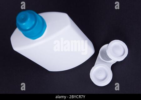 Corpo della lente e bottiglia d'acqua isolata in nero Foto Stock