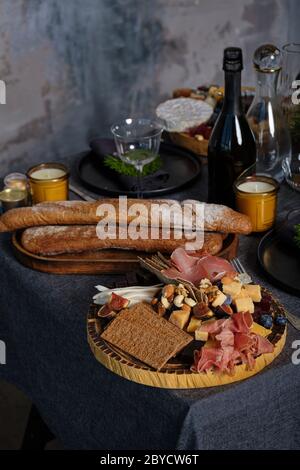 Pasto in piedi con cibo gustoso su una tovaglia blu. Tavolo posto in un interno indusziale con parete testurizzata Foto Stock