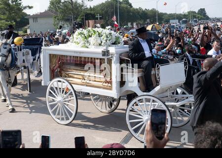 Una carrozza trainata da cavalli contenente il corpo di George Floyd si avvicina al cimitero dei Memorial Gardens di Houston, nella periferia di Houston, dove sarà sepolto accanto alla madre. La morte di Floyd, ucciso a fine maggio da un poliziotto bianco, ha scatenato proteste in tutto il mondo contro il razzismo e la brutalità della polizia. Foto Stock