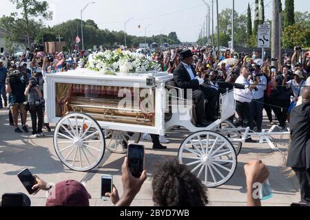 Una carrozza trainata da cavalli contenente il corpo di George Floyd si avvicina al cimitero dei Memorial Gardens di Houston, nella periferia di Houston, dove sarà sepolto accanto alla madre. La morte di Floyd, ucciso a fine maggio da un poliziotto bianco, ha scatenato proteste in tutto il mondo contro il razzismo e la brutalità della polizia. Foto Stock