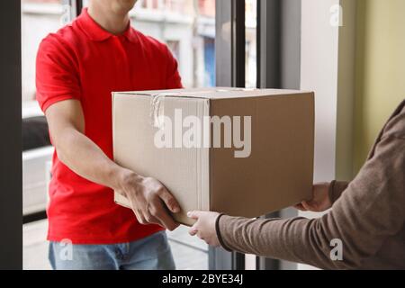 Ordine ricevuto. Donna riceve grande scatola di cartone dal corriere Foto Stock