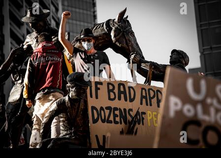 Giovani uomini salire statua a protesta BLM Foto Stock