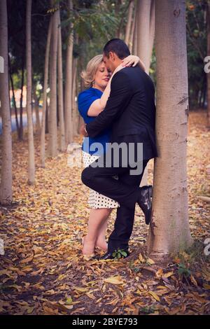 Bella coppia baciando e tenendo le mani che camminano nel legno Foto Stock
