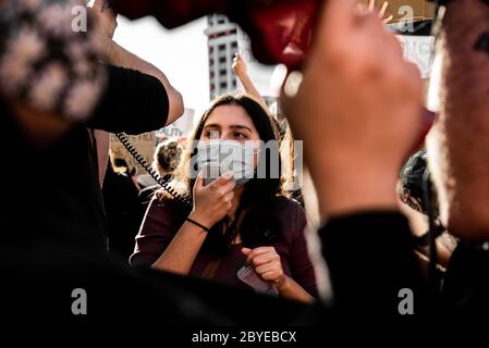 La giovane donna grida al megafono per protesta Foto Stock