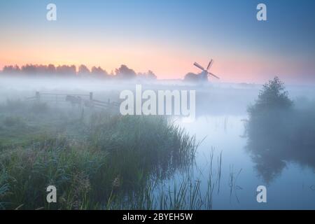 affascinante mulino a vento da fiume nebby Foto Stock