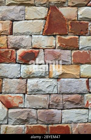 Moderne forme irregolari di pietra di colore rosso mattone sfondo a parete Foto Stock