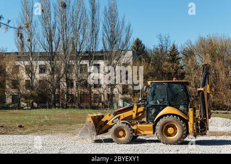 Dneprorudnoe/Ucraina - Aprile 08 2020: Un trattore versa la ghiaia dalla benna Foto Stock