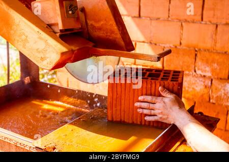 Lavoratore è l'utilizzo di power tool per pulire rende preciso taglio in rosso mattone, blocco. Esso utilizza azione abrasiva per slice attraverso il materiale come la lama ruota a hig Foto Stock