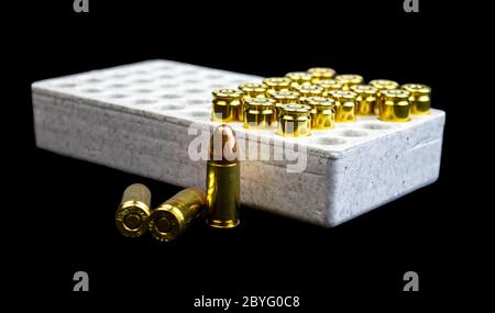 Alcuni proiettili da 9 mm isolati in una scatola bianca. Foto Stock