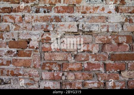 Un vecchio muro di mattoni decaduto come struttura. Foto Stock