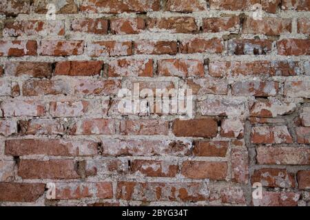 Un vecchio muro di mattoni decaduto come struttura. Foto Stock