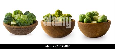 Diversi tipi di cavolo in una ciotola di legno. Broccoli, germogli di Bruxelles, cavolfiore romano isolato su sfondo bianco. Сabbage con spazio di copia per t Foto Stock