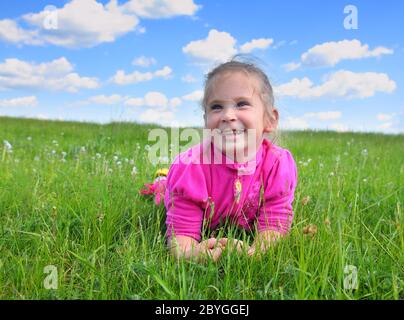 felice bambina che giace sull'erba Foto Stock