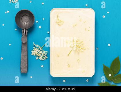 Gelato fatto in casa con fiori di sambuco in stampo e scooper in metallo rustico. Vista dall'alto. Foto Stock