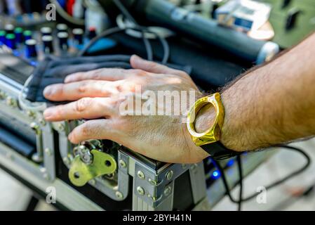 Pontelatone, Italia. 7 Giugno 2020. Mano e braccio di un uomo vicino a una console DJ e indossare un orologio senza un quadrante. Foto Stock