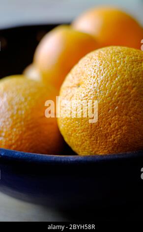 arance grandi in ciotola blu scuro Foto Stock