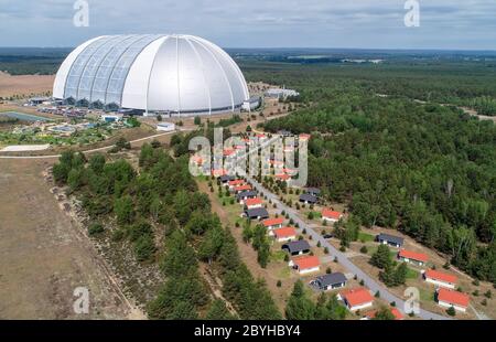 10 giugno 2020, Brandeburgo, Krausnick: Case vacanze si trovano di fronte alla sala del parco a tema delle isole tropicali (foto aerea scattata con un drone). Secondo le proprie dichiarazioni, il più grande mondo di vacanze tropicali d'Europa riprenderà le attività degli ospiti dal 15.06.2020. Il parco divertimenti era stato chiuso per tre mesi a causa del virus corona. Attualmente, nelle isole tropicali si stanno preparando in modo definitivo per la riapertura. Il concetto è dimezzare la capacità in modo che vi sia spazio sufficiente per ogni ospite per mantenere le normative sulla distanza. Fino a ulteriore avviso, i biglietti giornalieri sono disponibili solo Foto Stock