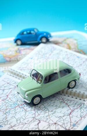 Due auto classiche in miniatura che attraversano una mappa stradale. Spazio per il testo. Concetto di viaggio e turismo in auto. Foto Stock