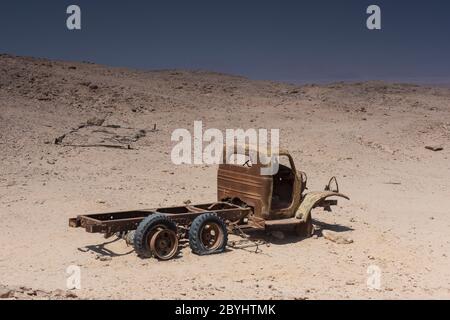 Resti di un vecchio camion arrugginito abbandonato derelict lasciato nel deserto a decadere Foto Stock